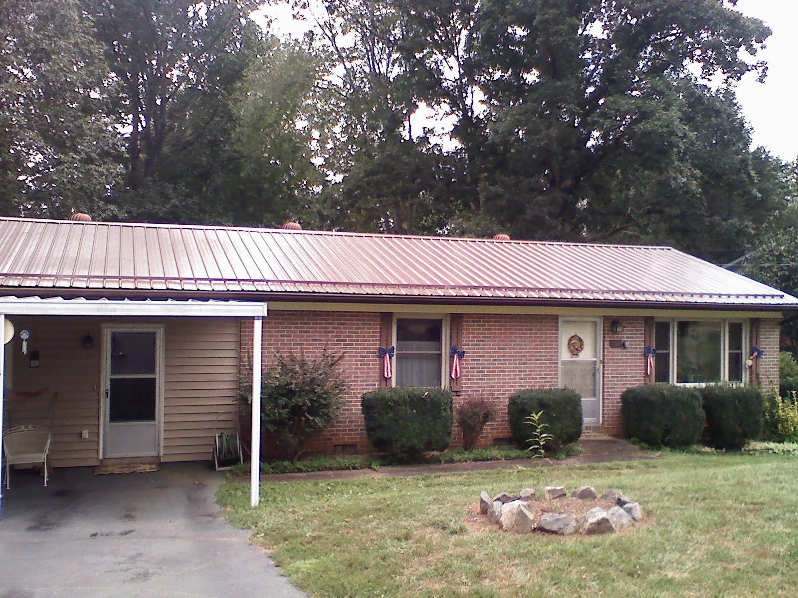 Bronze metal roof and carport on a brick ranch home — Roof Repair work by our crew in Valley Park