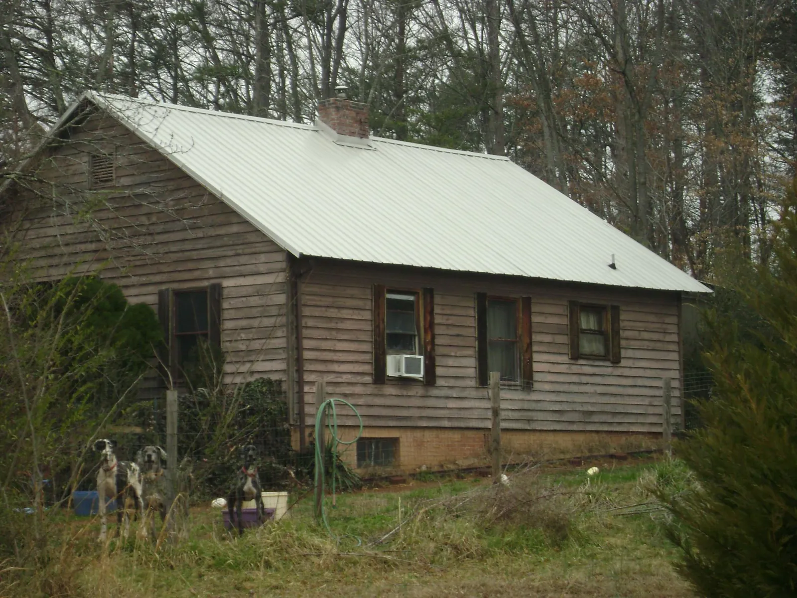 White metal roof on an old wood sided farmhouse, from a Metal Roof Installation job in Valley Park